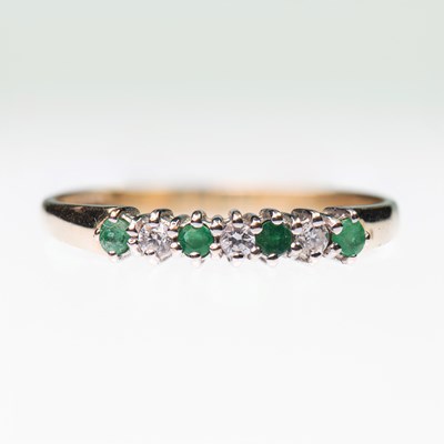 Lot 444 - A 9 CARAT GOLD EMERALD AND DIAMOND HALF HOOP RING