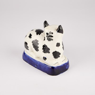 Lot 35 - A VICTORIAN STAFFORDSHIRE POTTERY MODEL OF A RECUMBENT CAT, CIRCA 1850