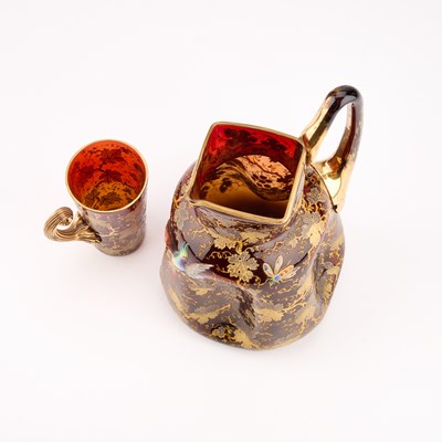 Lot 15 - A MOSER GILT AND ENAMELLED AMBERLINE GLASS PITCHER AND BEAKER, EARLY 20TH CENTURY