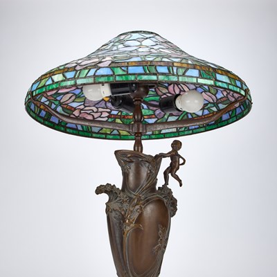 Lot 931 - A TIFFANY STYLE BRONZE TABLE LAMP WITH A LEADED AND STAINED GLASS SHADE