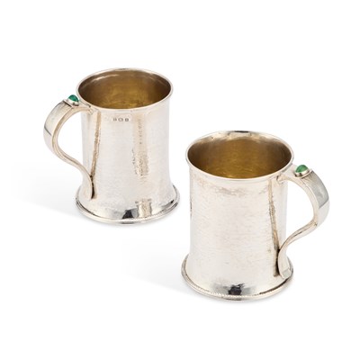 Lot 320 - A PAIR OF ARTS AND CRAFTS SILVER AND 'JEWELLED' MUGS