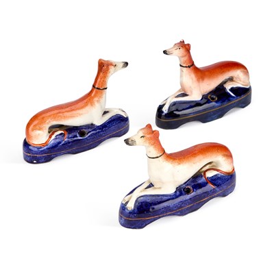 Lot 84 - THREE VICTORIAN STAFFORDSHIRE POTTERY GREYHOUND PEN HOLDERS