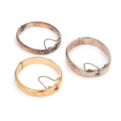 Lot 705 - THREE FOLIATE ENGRAVED HINGE-OPENING BANGLES