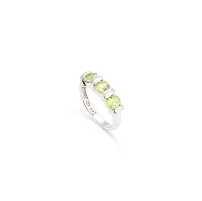 Lot 928 - A 9CT WHITE GOLD AND PERIDOT THREE STONE RING