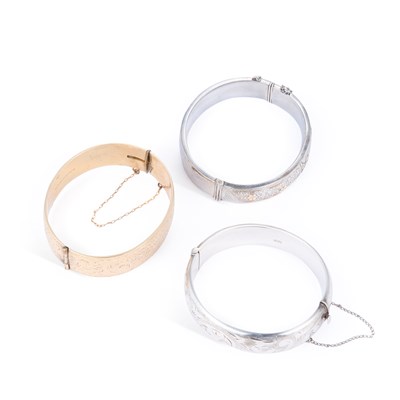 Lot 785 - TWO SILVER BANGLES AND A ROLLED GOLD BANGLE
