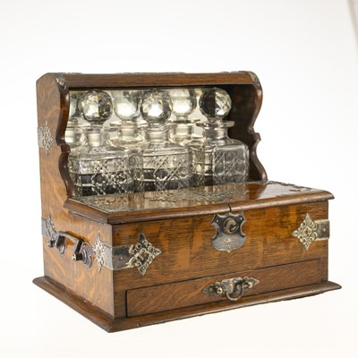 Lot 1151 - A LATE VICTORIAN OAK, SILVER-PLATED AND CUT-GLASS THREE-BOTTLE TANTALUS