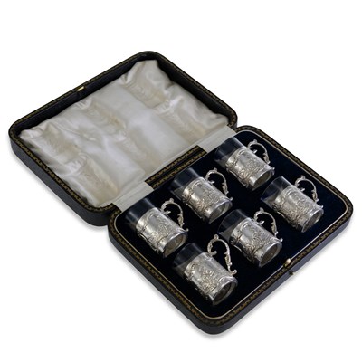 Lot 305 - A GEORGE V CASED SET OF SIX SILVER AND GLASS TOT CUPS
