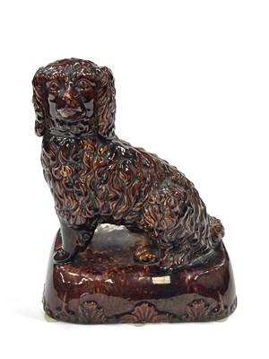 Lot 91 - A TREACLE GLAZED POTTERY FIGURE OF A SPANIEL