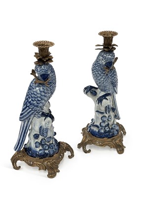 Lot 115 - A PAIR OF BRASS-MOUNTED BLUE AND WHITE PORCELAIN PARROT CANDLESTICKS