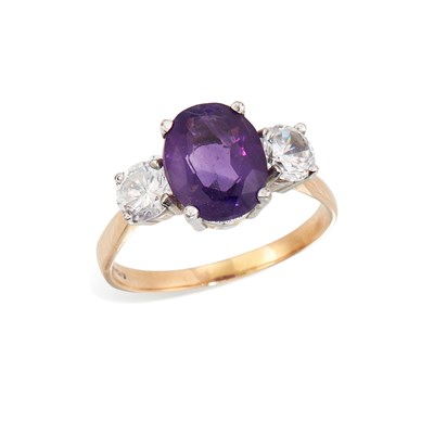Lot 593 - A 9 CARAT GOLD AMETHYST AND WHITE PASTE THREE STONE RING